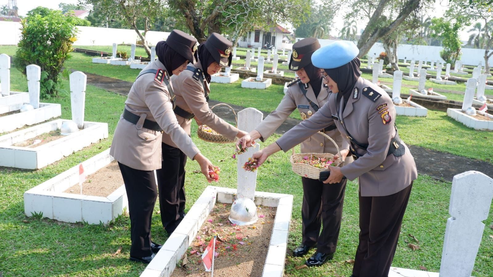Personel Polwan Polda Kalbar melakukan prosesi tabur bunga di pusara pahlawan dalam upacara ziarah di Taman Makam Pahlawan Dharma Patria Jaya, Kubu Raya, untuk memperingati Hari Jadi ke-77 Polwan RI, Kamis (28/8/2025).