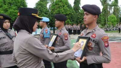 Kapolres Landak, AKBP Devi Ariantari secara simbolis mencoret foto dua anggotanya saat upacara PTDH di Lapangan Mapolres Landak. (Dok. Polres Landak)