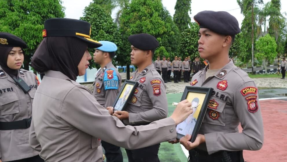 Kapolres Landak, AKBP Devi Ariantari secara simbolis mencoret foto dua anggotanya saat upacara PTDH di Lapangan Mapolres Landak. (Dok. Polres Landak)