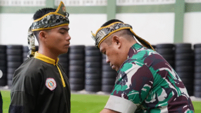 Kajasdam XII/Tpr, Kolonel Arm Kusdi Yuli Suhanda, menyematkan sabuk kepada salah satu peserta yang baru saja dikukuhkan sebagai kader pelatih pencak silat militer. (Dok. Instagram/@kodamtanjungpura)
