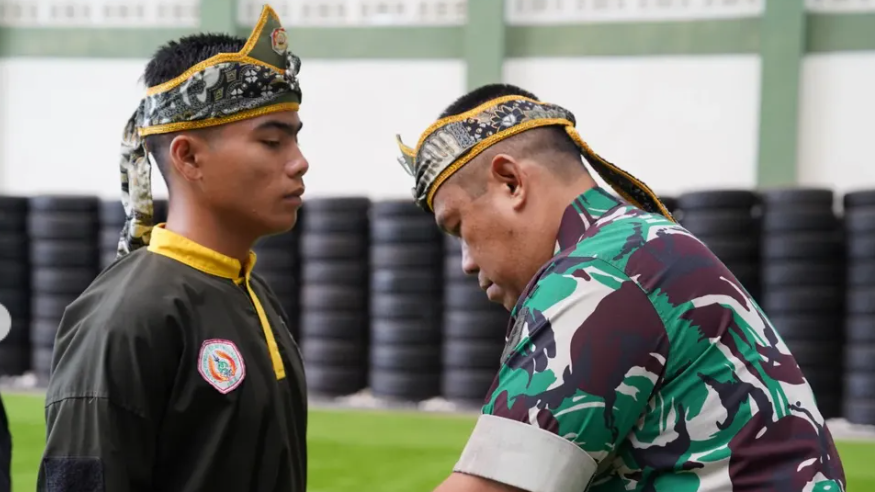 Kajasdam XII/Tpr, Kolonel Arm Kusdi Yuli Suhanda, menyematkan sabuk kepada salah satu peserta yang baru saja dikukuhkan sebagai kader pelatih pencak silat militer. (Dok. Instagram/@kodamtanjungpura)
