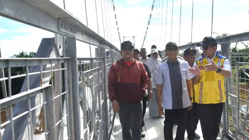 Jembatan Gantung Munggu Emas yang kokoh membentang di atas sungai di Kecamatan Kuala Mandor, Kabupaten Kubu Raya, dengan latar belakang pepohonan hijau. (Dok. Instagram/@prokopim_kuburaya)