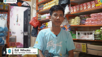 Edi Winata, pemilik Toko Usaha Jaya, di depan toko sembakonya yang berkembang berkat dukungan permodalan dari Bank Kalbar. (Dok. Instagram/@bankkalbar_official)