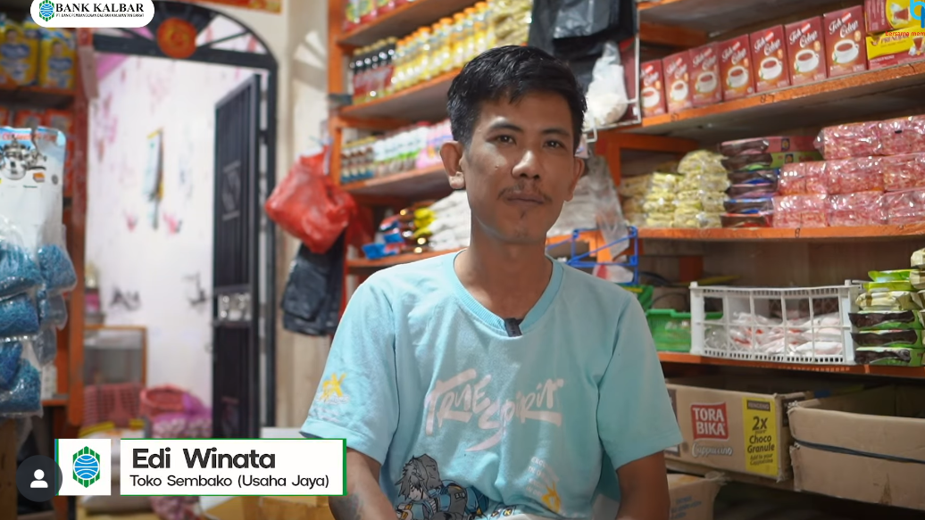 Edi Winata, pemilik Toko Usaha Jaya, di depan toko sembakonya yang berkembang berkat dukungan permodalan dari Bank Kalbar. (Dok. Instagram/@bankkalbar_official)