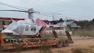 Pemandangan tak biasa sebuah helikopter milik BNPB yang diangkut menggunakan truk tronton di jalanan Kabupaten Sanggau, Kalbar, setelah mengalami kendala teknis. (Dok. Ist)