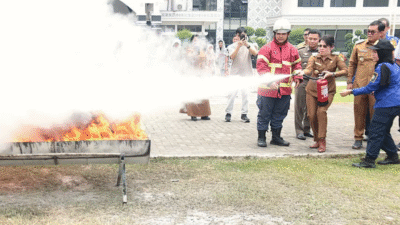 Seorang peserta mempraktikkan cara menggunakan Alat Pemadam Api Ringan (APAR) dalam workshop keselamatan kerja Pemkot Singkawang. (Dok. Instagram/@prokopimsingkawang)