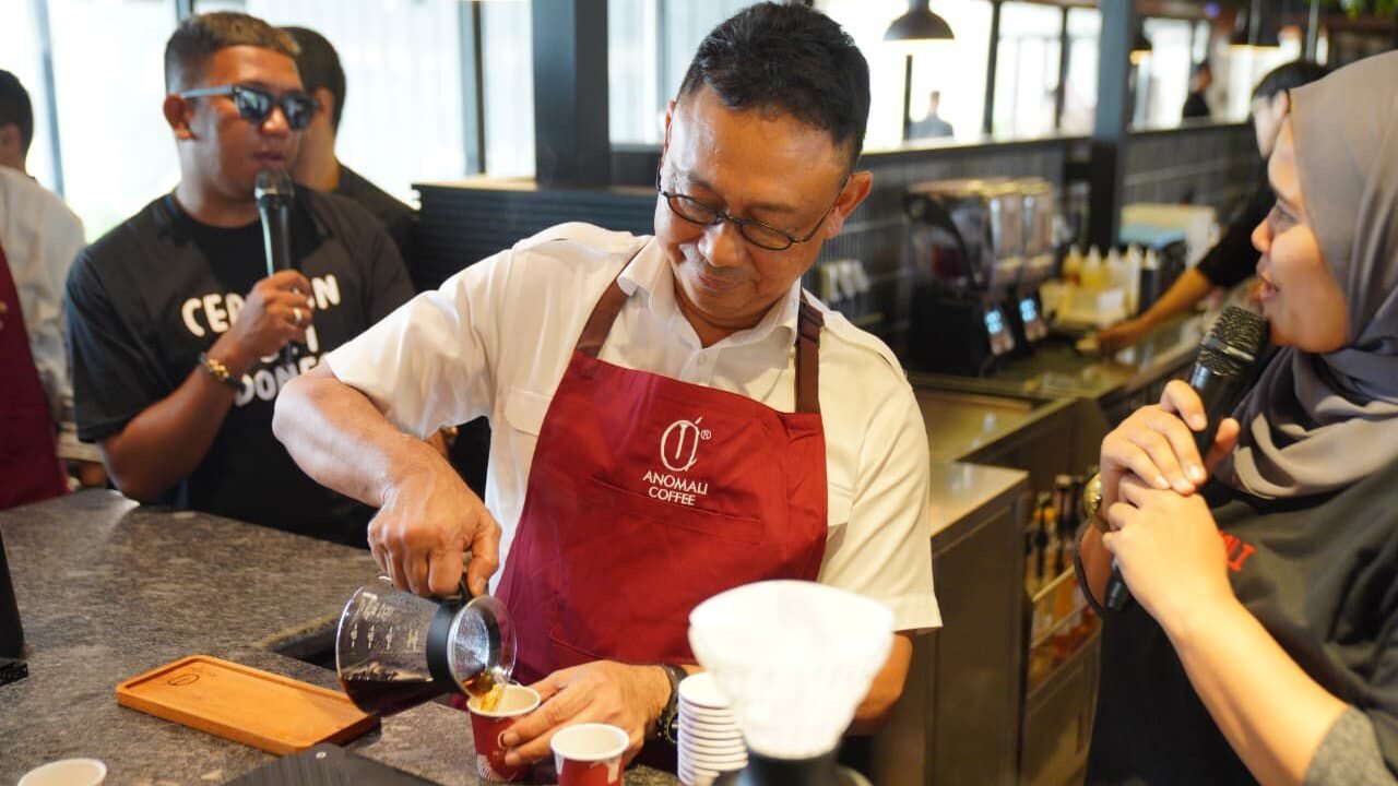 Wali Kota Pontianak, Edi Rusdi Kamtono, saat mencoba menjadi barista dan meracik kopi di acara peresmian Anomali Coffee di Jalan Mujahidin, Jumat (12/9/2025).