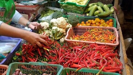 Ilustrasi seorang pedagang sayuran melayani pembeli di pasar tradisional. Harga sembako di Kabupaten Sambas terpantau stabil dengan beberapa komoditas penting mengalami penurunan harga.