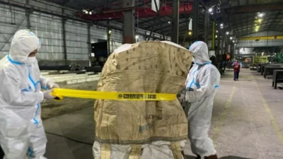 Petugas gabungan dari berbagai instansi pemerintah mengenakan pakaian pelindung khusus (hazmat) saat melakukan dekontaminasi material radioaktif Cesium-137 di Kawasan Industri Cikande, Kabupaten Serang, Banten.