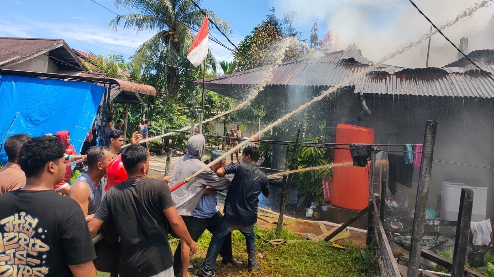 Petugas pemadam kebakaran berjuang memadamkan api yang melahap sebuah rumah di Desa Sungai Ambawang Kuala, Kubu Raya, pada Minggu (21/9/2025).