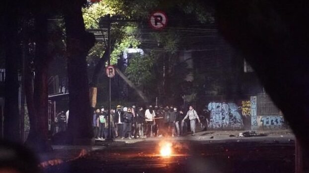 Bentrokan pecah di Jalan Tamansari, Kota Bandung, setelah demonstrasi mahasiswa dibubarkan paksa oleh aparat gabungan TNI-Polri. Foto ini mengabadikan sisa-sisa chaos di lokasi kejadian, yang memicu berbagai versi kronologi dari pihak kampus dan kepolisian.