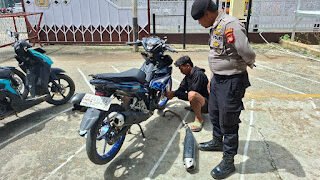 Seorang pengendara yang melanggar diminta ganti knalpot standar di tempat sebagai edukasi.(Dok. Polres Sanggau)