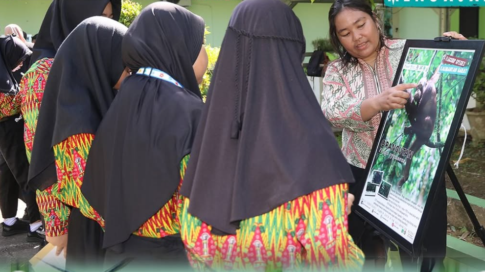 Siswa-siswi SDN 28 Pontianak berfoto bersama dengan staf Tim Edukasi BKSDA Kalbar di depan poster satwa liar dilindungi. (Dok. Instagram/@bksda_kalbar)