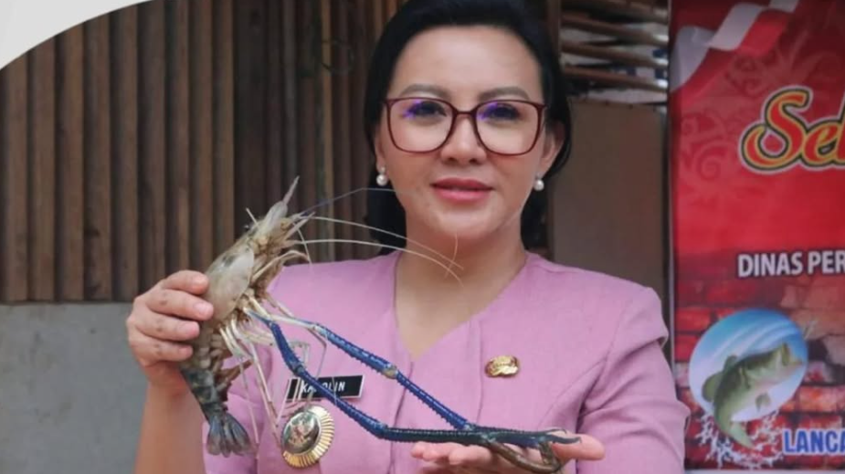 Bupati Landak Karolin Margret Natasa memegang udang galah hasil panen saat sosialisasi ilegal fishing bersama komunitas pemancing di Tepian Sungai Landak. (Dok. Instagram/@diskominfo_landak)
