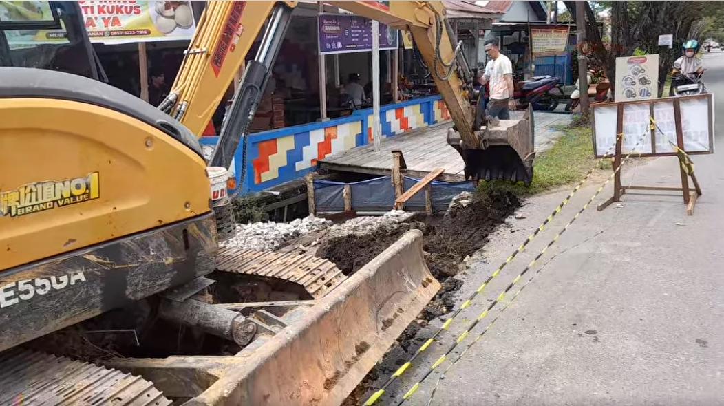 Sebuah alat berat sedang membongkar struktur jembatan di Jalan KH Mansyur, Ketapang, sebagai bagian dari proyek perbaikan drainase kota. (Dok. Ist)
