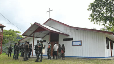 Sejumlah personel TNI dan warga berkumpul di depan Gereja Santo Yohanes Paulus II di Stasi Okpol, Papua Pegunungan, yang direnovasi. (Dok. X/@kemhan_RI)