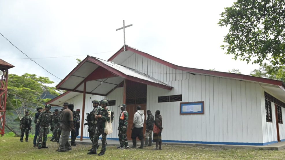 Sejumlah personel TNI dan warga berkumpul di depan Gereja Santo Yohanes Paulus II di Stasi Okpol, Papua Pegunungan, yang direnovasi. (Dok. X/@kemhan_RI)