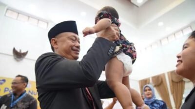 Wali Kota Pontianak Edi Rusdi Kamtono menggendong balita sebelum ditimbang berat badannya.