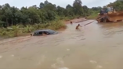 Warga berupaya keras mengevakuasi sebuah mobil yang terseret arus deras akibat banjir parah di wilayah Batang Belian, Ketapang