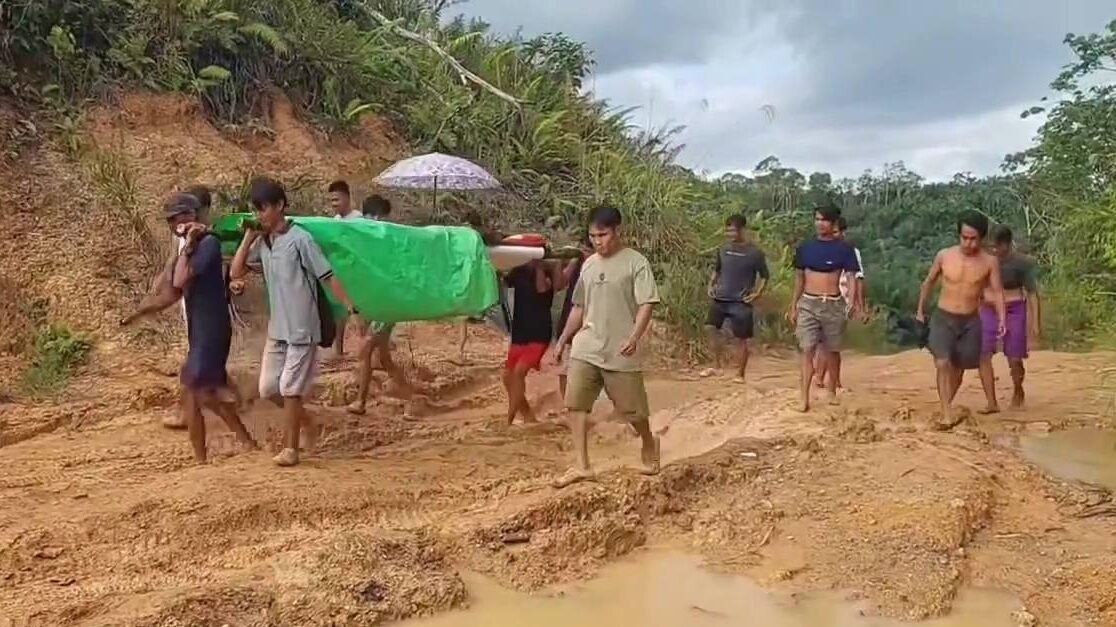 Warga Dusun Kelepuk, Kecamatan Air Besar, Kabupaten Landak, terpaksa bergotong-royong menandu seorang warga yang sakit untuk berobat akibat kondisi jalan yang rusak parah dan berlumpur.