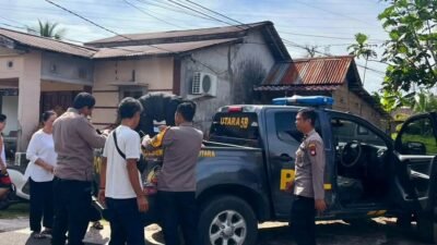 Petugas kepolisian saat mengamankan seorang pemuda yang meresahkan warga akibat pengaruh minuman keras.