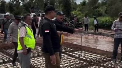 Bupati Ketapang, Alexander Wilyo, saat berdialog dengan pekerja di lokasi perbaikan jalan Pelang–Kepuluk Batu Tajam yang dikerjakan melalui CSR Gotong Royong, Minggu (16/11/2025).