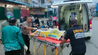 Petugas kepolisian saat mengevakuasi jenazah pria yang ditemukan meninggal dunia di tepi Jalan Jurusan Anjungan, Sungai Pinyuh, Sabtu (29/11/2025).