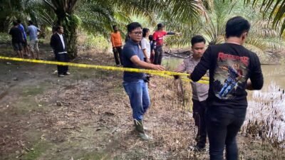 Personel Polsek Tayan Hulu memasang garis polisi di lokasi kejadian tebing longsor yang menewaskan seorang bocah (VDP) di Dusun Peruan Dalam, Tayan Hulu, Rabu (5/11/2025).