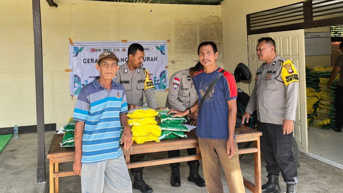 Penyaluran beras kepada warga dalam kegiatan Gerakan Pangan Murah di Mapolsek Kembayan, Minggu (16/11/2025).