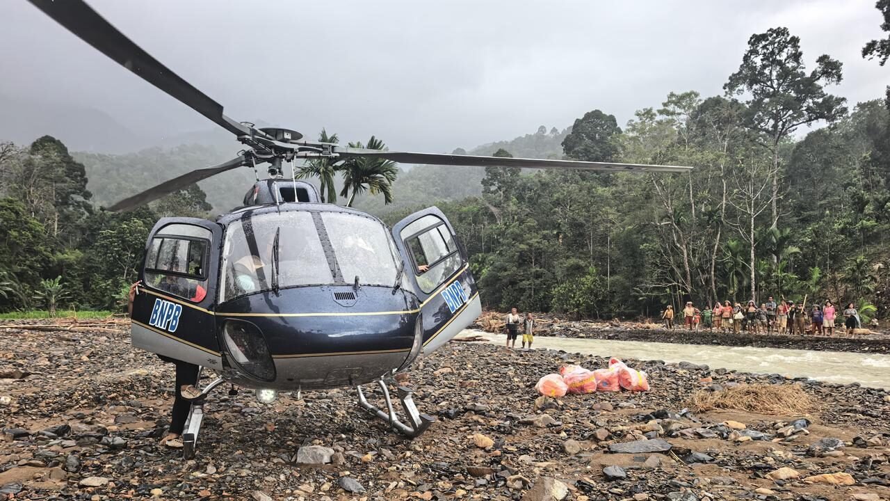 Helikopter BNPB mendarat di tepi sungai demi antarkan bantuan warga yang terisolir akibat bencana hidrometeorologi di Desa Sihaporas, Kecamatan Pinangsori, Kabupaten Tapanuli Tengah, Sumatra Utara, Sabtu (29/11/2025).