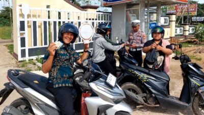 Seorang pengendara motor dengan senyum sumringah menunjukkan kelengkapan surat kendaraannya kepada petugas Polres Kubu Raya saat Operasi Zebra Kapuas 2025, Kamis (27/11/2025).