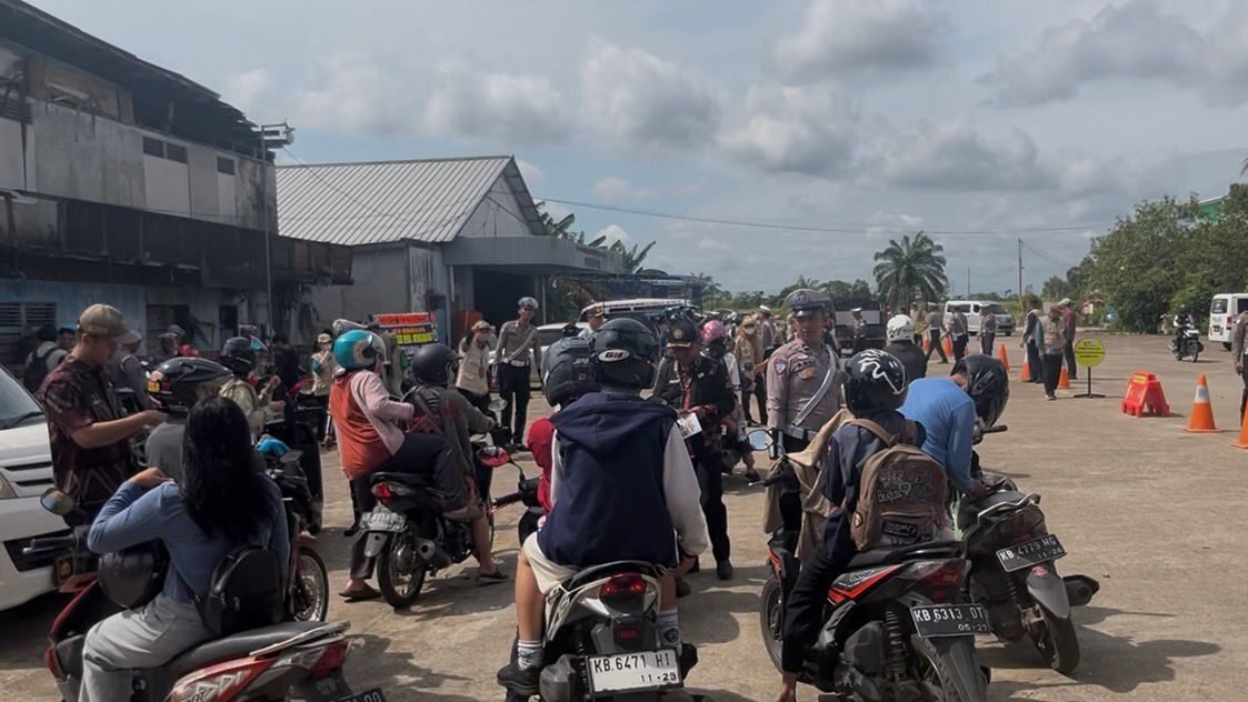 Personel Ditlantas Polda Kalbar saat melakukan pemeriksaan surat-surat kendaraan kepada pengendara di Jalan Adisucipto dalam rangka Operasi Zebra Kapuas 2025, Kamis (27/11/2025).