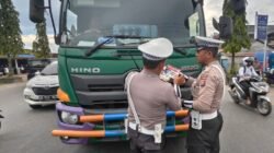 Personel Satlantas Polres Kubu Raya saat membagikan brosur edukasi tertib berlalu lintas kepada pengendara di kawasan Simpang Kapur, Sungai Raya, Kamis (20/11/2025).