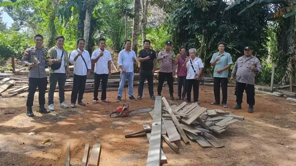 Personel Polsek Putussibau Selatan bersama perangkat desa saat melakukan pembongkaran dan pemusnahan arena sabung ayam menggunakan mesin chainsaw di Desa Sayut, Rabu (26/11/2025).
