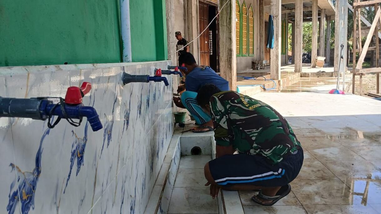 Personel Satgas TMMD Kodim 1208/Sambas bersama warga bergotong royong membersihkan tempat wudhu Masjid Jamuatul Muslimin di Desa Ratu Sepudak, Rabu (5/11/2025).