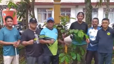 Kepala Dinas Pertahanan Pangan dan Perikanan Ketapang, Adi Mulia (tengah, baju biru), bersama staf memegang bibit pohon Belian yang akan ditanam di hari terakhirnya sebagai PNS. (Dok. Ist)