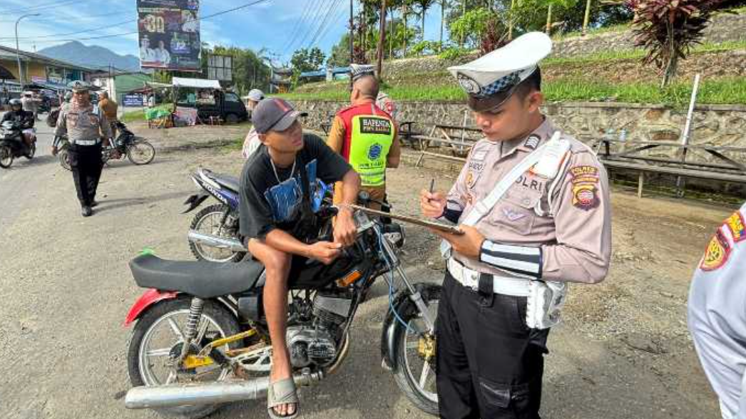 Seorang petugas Satlantas Polres Bengkayang sedang memberikan teguran tertulis kepada seorang pengendara motor dalam operasi gabungan lintas sektoral. (Dok. HO/Faktakalbar.id)