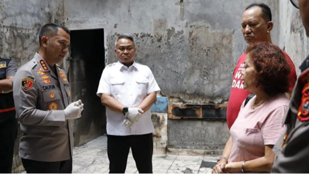 Kapolrestabes Medan Kombes Jean Calvijn Simanjuntak (kiri, berseragam polisi) sedang berbicara dengan seorang wanita (saksi/korban) di lokasi olah TKP kebakaran rumah. (Dok. Ist)