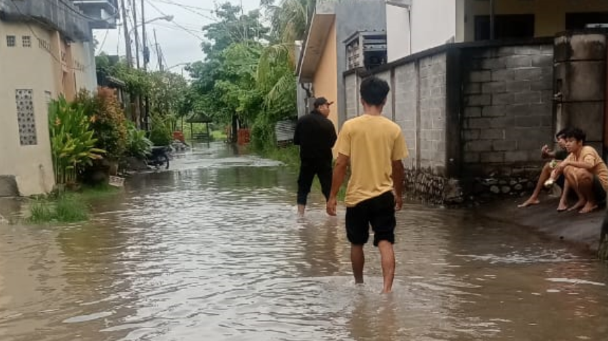 Sejumlah warga berjalan menerobos banjir setinggi 30 cm yang merendam jalan pemukiman di Kelurahan Abian Tubuh Baru, Kota Mataram. (Dok. HO/Faktakalbar.id)