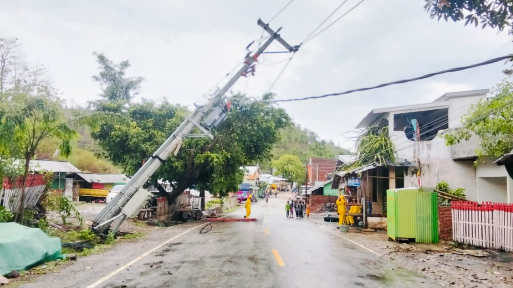 Kondisi jalan pascabanjir bandang di Kecamatan Rasanae Barat, Bima, yang menunjukkan sebuah tiang listrik miring nyaris roboh. (Dok. HO/Faktakalbar.id)
