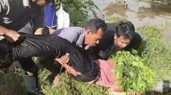 Warga mengevakuasi mayat korban di lokasi kejadian penganiayaan di Jalan Raya depan SDN 11 Jongkat, Mempawah, tempat korban tewas ditemukan. (Dok. Ist)