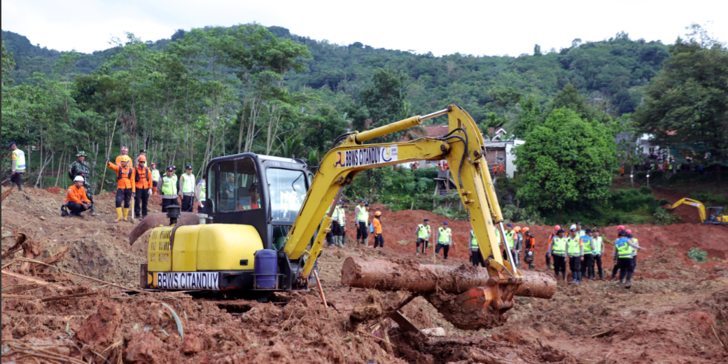 Satu unit ekskavator (alat berat) sedang melakukan pengerukan di lokasi bencana tanah longsor, diawasi oleh tim SAR gabungan. (Dok. HO/Faktakalbar.id)
