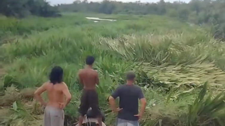 Tiga orang warga di atas perahu motor terhenti di Sungai Kuala Simpang, Kecamatan Sungai Ambawang, yang permukaannya tertutup total oleh rumput dan gulma. (Dok. Ist)