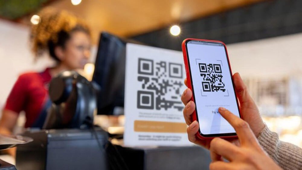 Ilustrasi seorang pelanggan melakukan pembayaran menggunakan QRIS. Pengguna QRIS di Indonesia kini telah mencapai 58 juta, jauh melampaui pengguna kartu kredit. (Dok. QRIS)