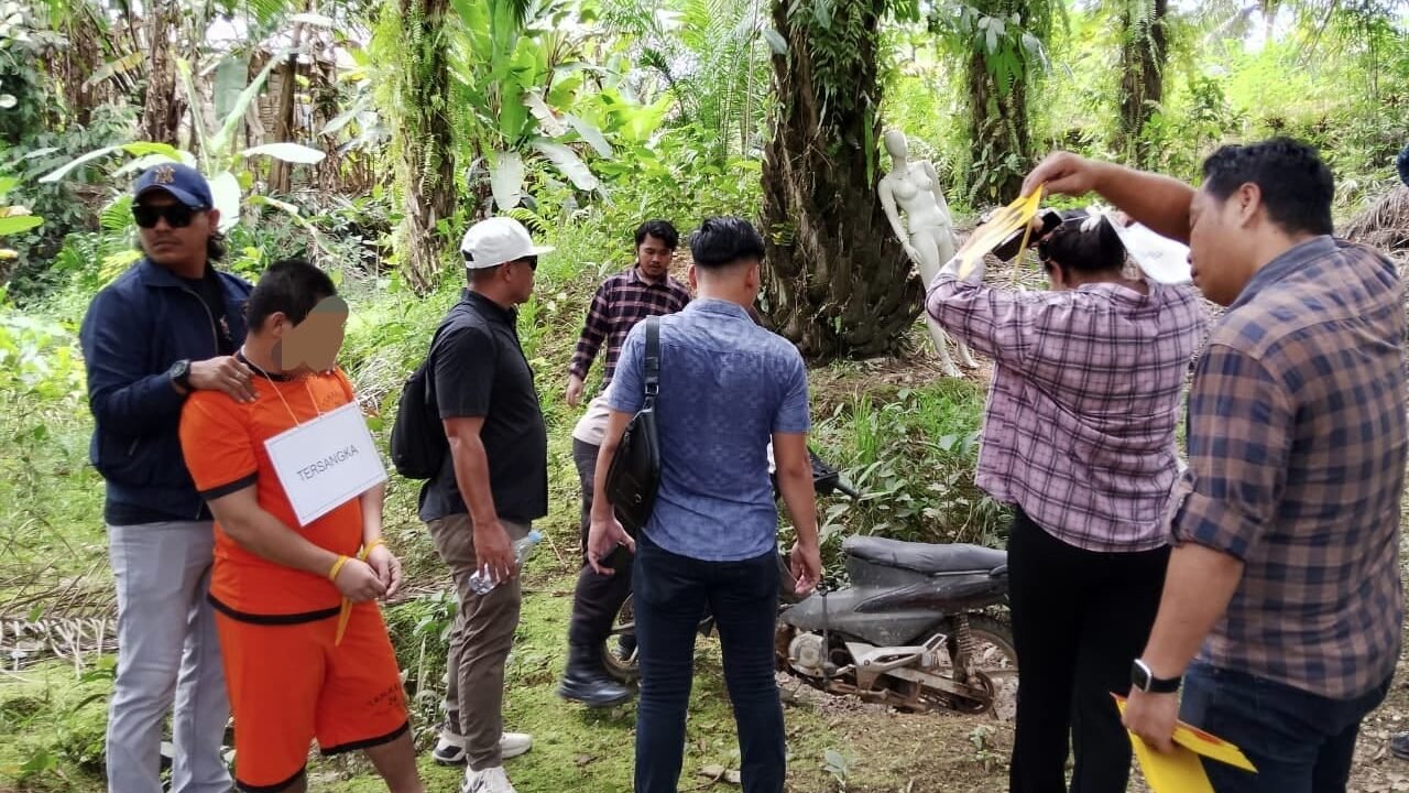 Tersangka H (memakai baju tahanan) saat memeragakan salah satu adegan dalam rekonstruksi kasus penemuan mayat di TKP Desa Serimbu, Kecamatan Air Besar, Landak, Selasa (11/11/2025). (Dok. Ist)