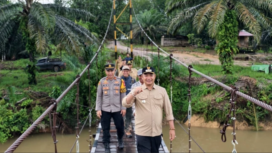 Bupati Ketapang Alexander Wilyo didampingi Kapolsek meninjau Jembatan Gantung Sengkuang Merabung yang baru selesai diperbaiki. (Dok. HO/Faktakalbar.id)