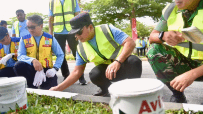 Bupati Kubu Raya Sujiwo bersama Kepala BPJN Kalbar berjongkok mengecat beton pembatas jalan dalam kegiatan preservasi Jalan Supadio. (Dok. HO/Faktakalbar.id)