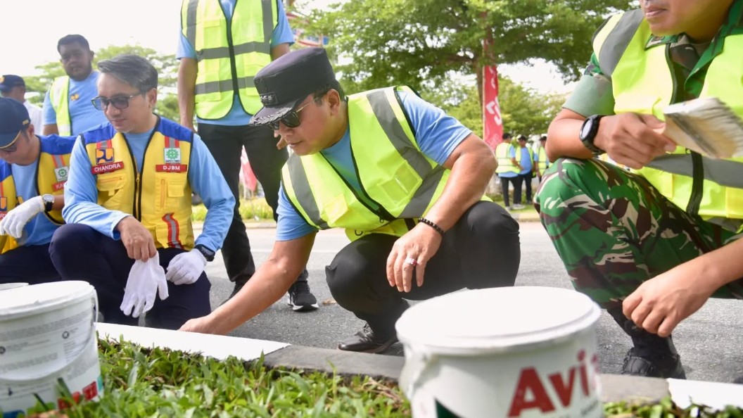 Bupati Kubu Raya Sujiwo bersama Kepala BPJN Kalbar berjongkok mengecat beton pembatas jalan dalam kegiatan preservasi Jalan Supadio. (Dok. HO/Faktakalbar.id)