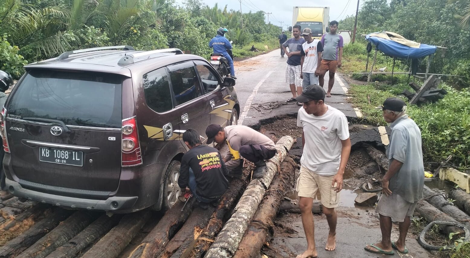"Akibat kayu penyangga lapuk, sebuah mobil Avanza terperosok di jembatan Desa Teluk Melano, Simpang Hilir. Polisi dan warga bahu-membahu lakukan evakuasi."