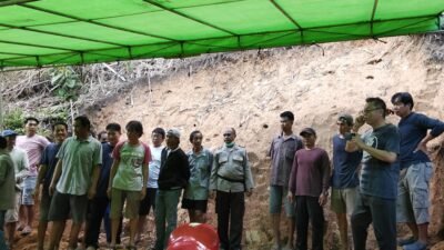 "Prosesi pemakaman warga Desa Alur Bandung, Bapak Ajung, berjalan lancar. Personel Polsek Teluk Batang bantu pengaturan lalu lintas dan keamanan di lokasi duka."